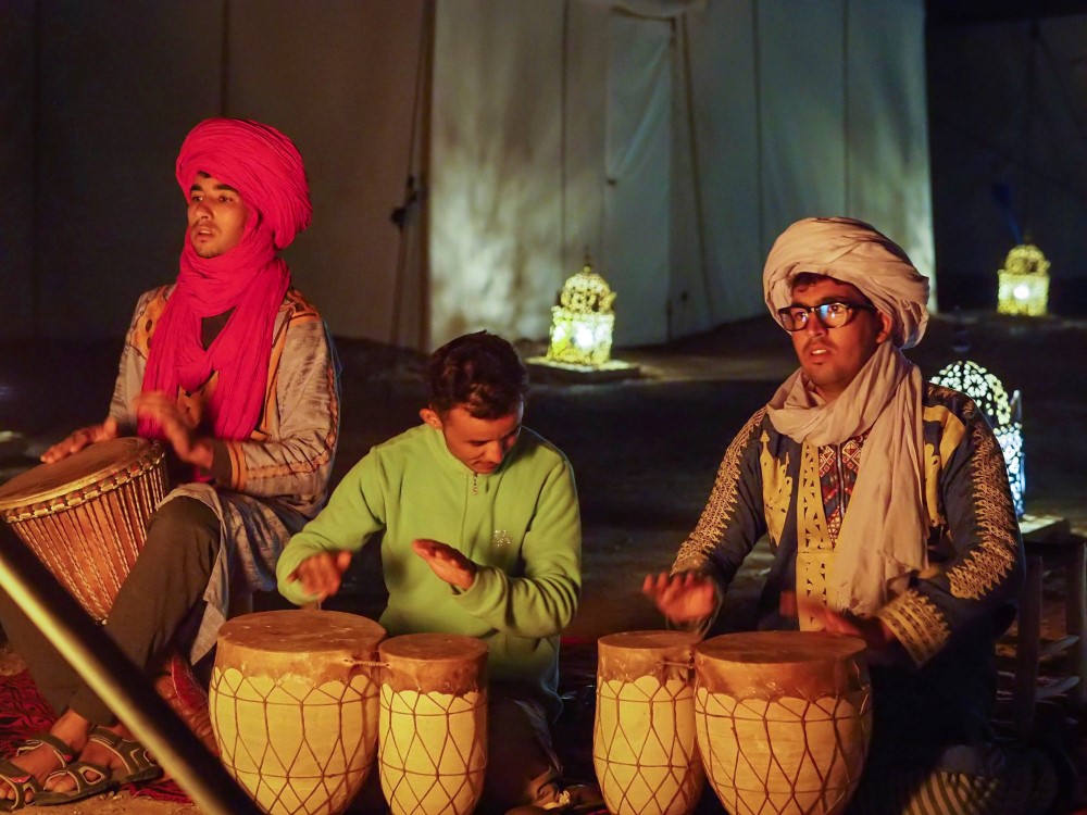 Berbers playing drums at a Sahara desert camp at night