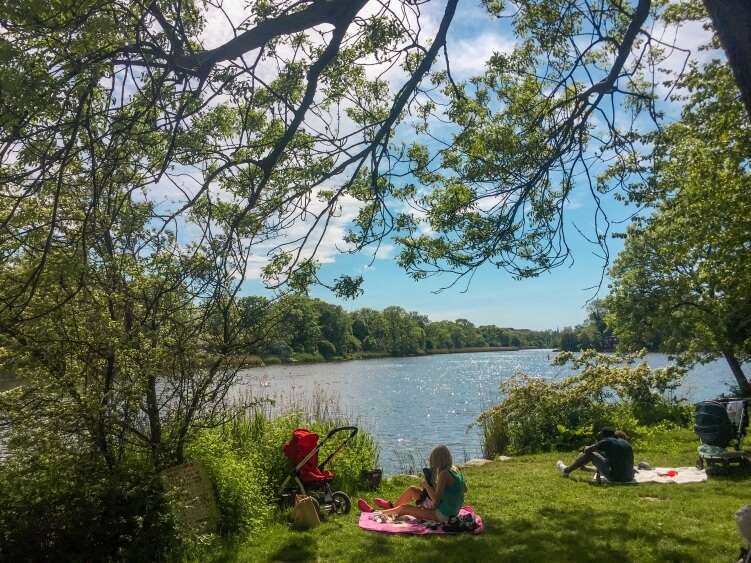 Picnic and sunbathing next to the Christiania lake on a hot summer day, a spot that's definitely among Copenhagen hidden gems