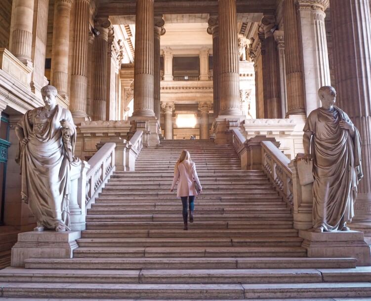 A massive staircase with statues and columns near the entrance of the Palace of Justice in Brussels