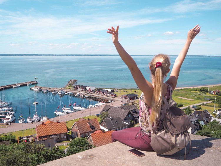 Me sitting at a viewpoint above Kyrkbacken village on the island of Hven, one of the best day trips from Copenhagen