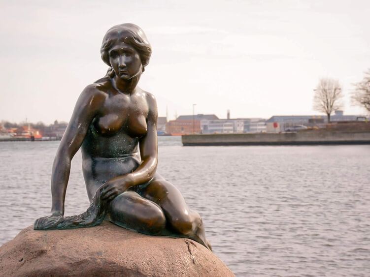 The bronze statue of the Little Mermaid - one of the most popular tourist attractions in Copenhagen and a place you should add to your Copenhagen bucket list