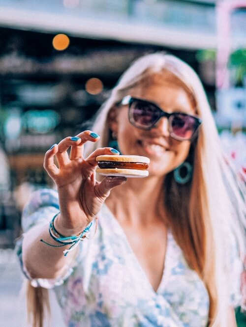 Me holding an alfajor cookie with dulce de leche in Torvehallerne, Copenhagen
