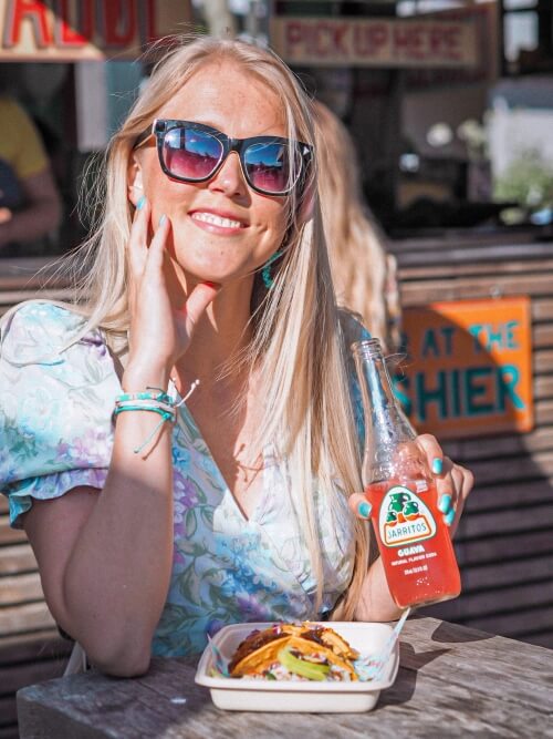 a girl enjoying tacos at Torvehallerne street food market in Copenhagen