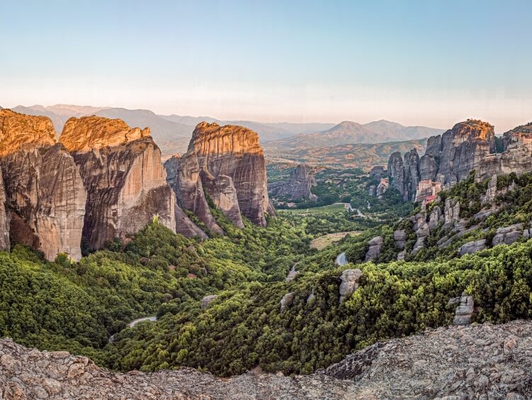 A view over unique sandstone rock formations and lush green vegetation in Meteora, Greece