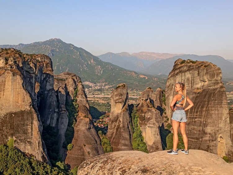 Me standing on a rock at Psaropetra lookout with views of vertical rock pillars and green vegetation