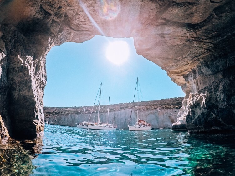 The opening of a sea cave in Kleftiko with sailing boats in the background