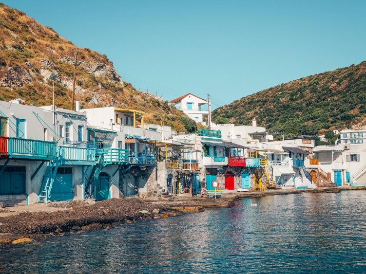 A row of traditional white boat houses called 'syrmata' with colorful doors in the picturesque fishermen village of Klima on Milos Island