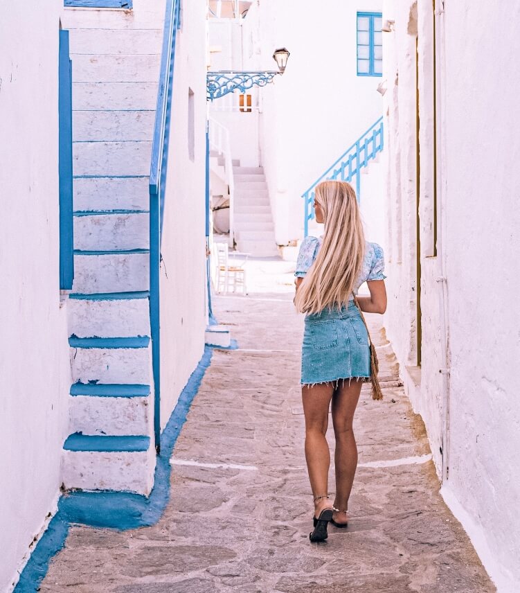 Me walking along narrow whitewashed streets lined with traditional Cycladic houses in Plaka, the capital of Milos Island