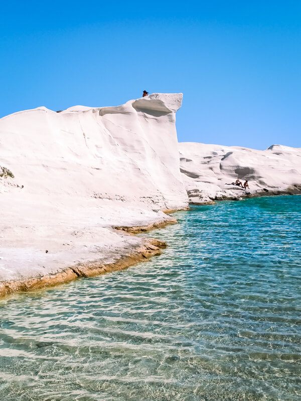 Smooth white moon-like cliffs and emerald water at Sarakiniko Beach, one of the most famous places in Milos.