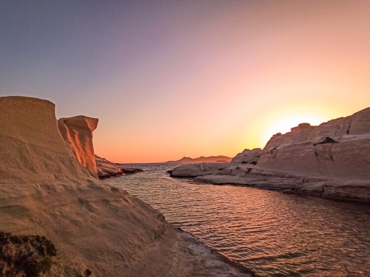 Smooth white cliffs and colroful sky during sunrise at Sarakiniko beach, a must-have experience in Milos