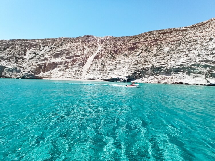 Vivid turquoise waters and steep white cliffs surrounding Gerakas Bay in Milos