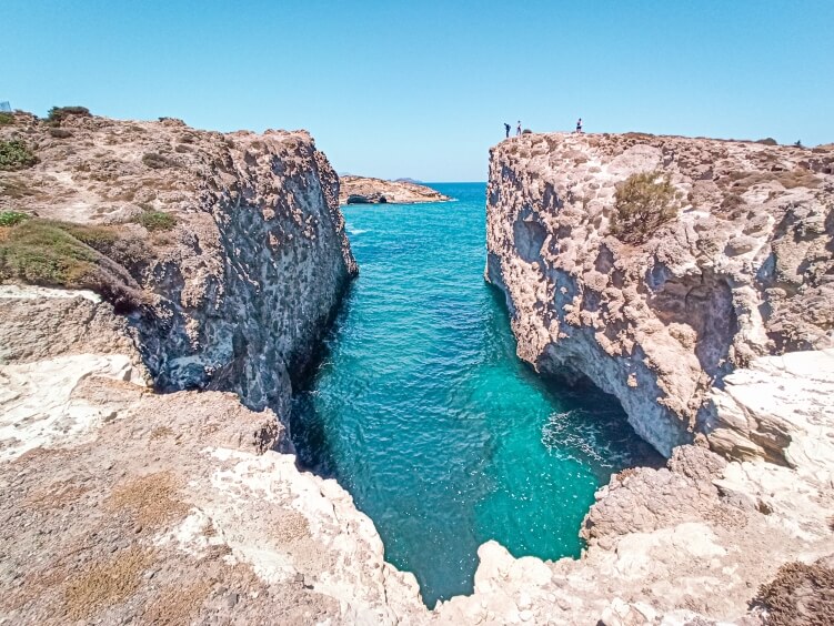 The narrow canal and crystal clear waters of Papafragas Beach, one of the most unique Milos beaches
