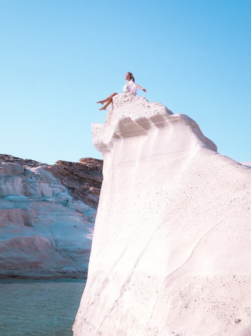 me sitting on the edge of a white cliff on Sarakiniko Beach, Milos