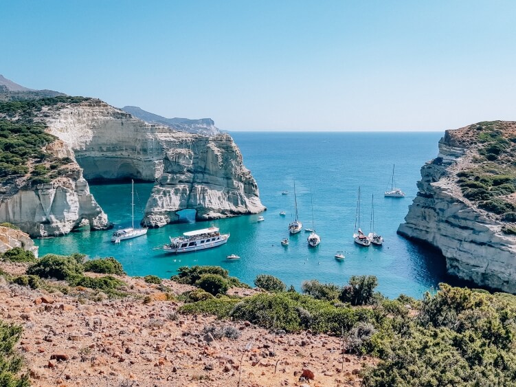 A view of the iconic Kleftiko bay with white rocks and turquoise water on Milos, one of the best hikes in Greece