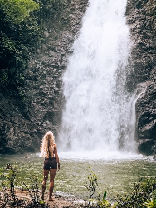 A girl looking at Montezuma waterfall, a place that has to be included in your 10 day Costa Rica itinerary