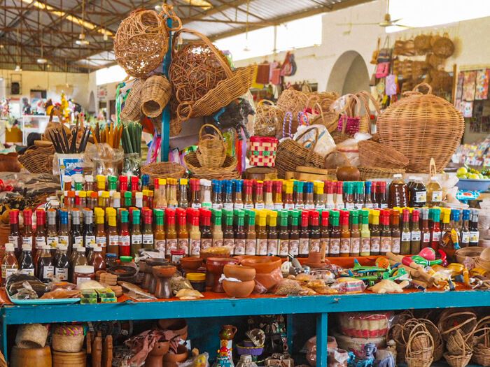 A selection of Mexican salsas in colorful bottles and locally made handicrafts at the Municipal Market of Valladolid