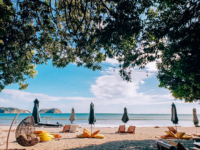 orange sun chairs and umbrellas on Samara beach in Costa Rica