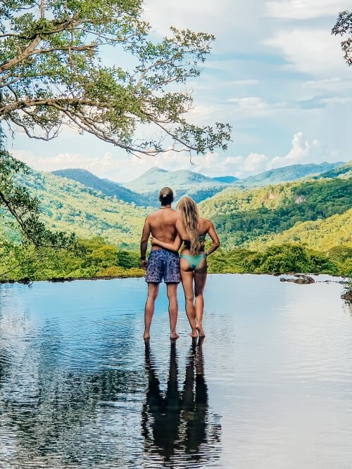 a couple standing in a natural infinity pool during Boca da Onca ecotour in Bonito