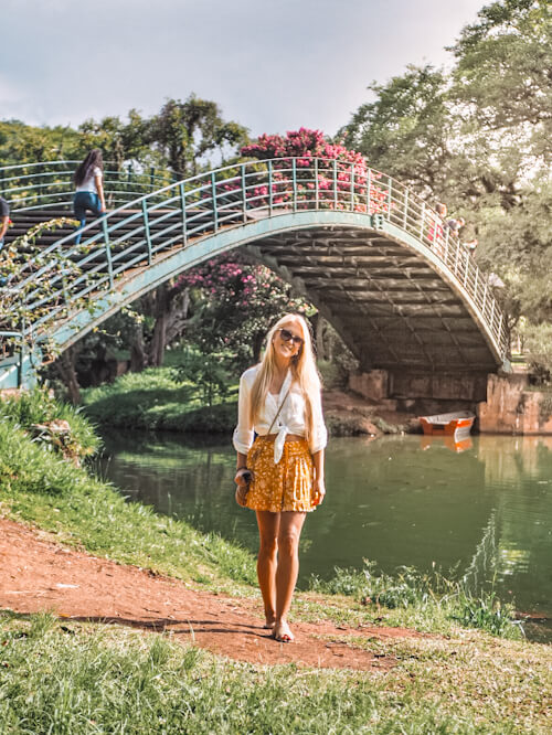 A girl standing in front of a river in Ibirapuera Park in Sao Paulo