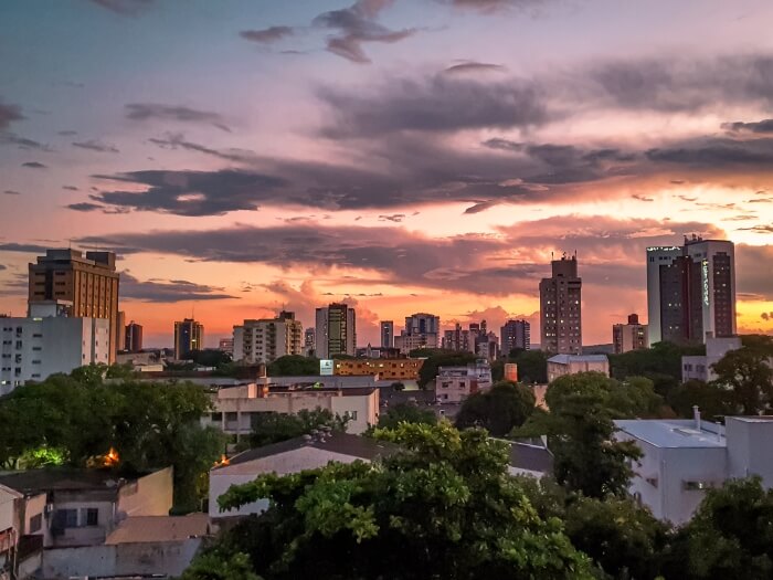 a view over the high rise buildings of Foz do Iguacu with a backdrop of pink sunset sky