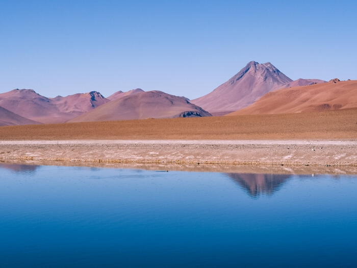 Altiplanic lake and red volcanoes on the Ruta de los Salares road, one of the top things to do in the Atacama Desert, Chile