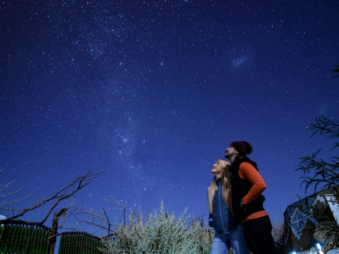 A couple stargazing at the night sky on an Atacama Desert astronomical tour 