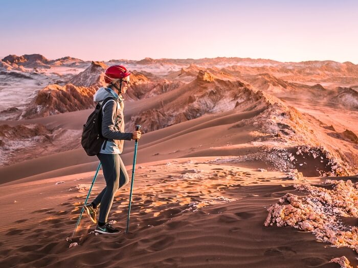 A woman hiking through the Mars-like landscape of Vallecito in Cordillera de la Sal, one of the best hikes in the Atacama Desert