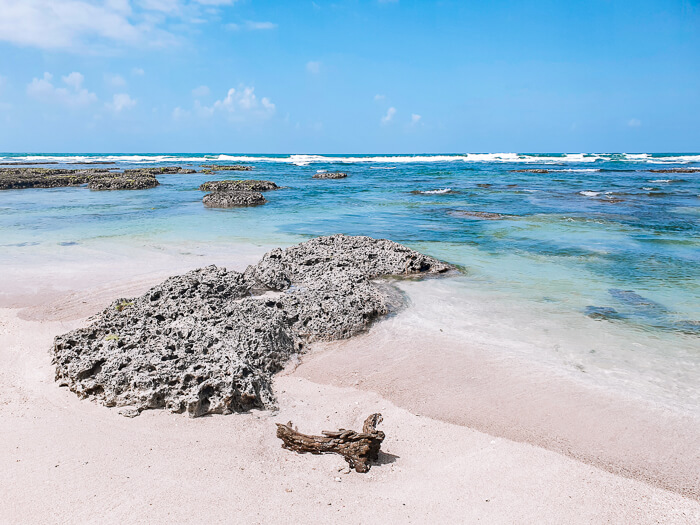 Natural pools with clear calm water and a white sand beach on Isla Colon