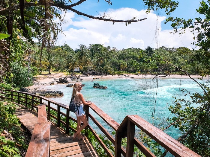 A girl standing on a wooden walkway, enjoying a view over Red Frog Beach, one of the best beaches in Bocas del Toro.