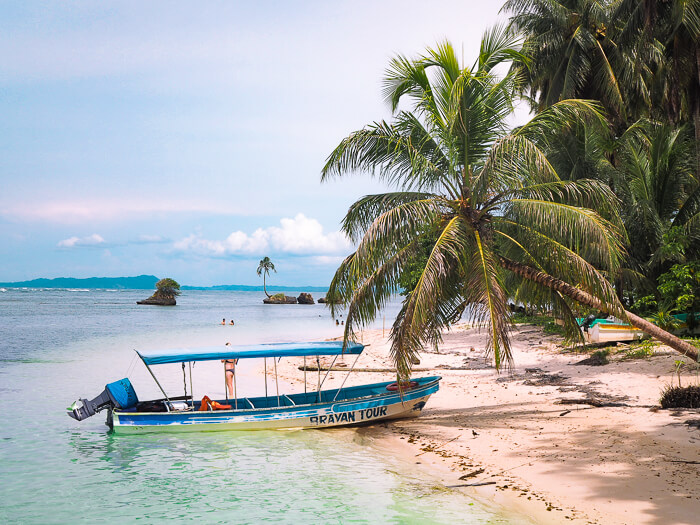 A small boat docked on a sandy beach at Cayo Zapatilla, one of the most beautiful places in Bocas del Toro