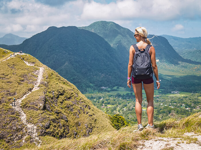 A woman hiking La India Dormida trail and admiring the mountainous scenery of El Valle de Anton in Panama