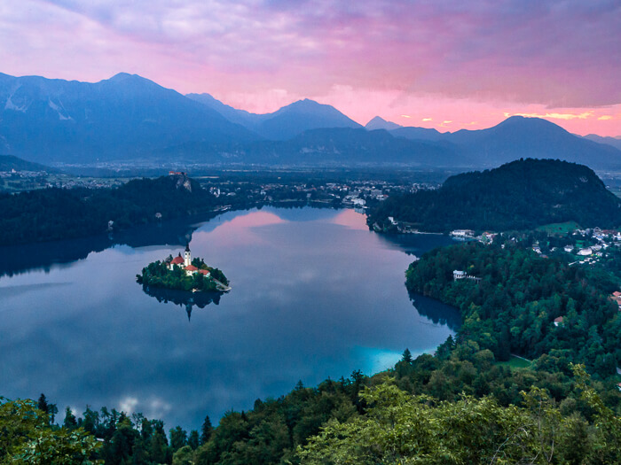 Pink sky at sunrise at Lake Bled, one of the most beautiful places in Slovenia and a mandatory part of every Slovenia road trip.
