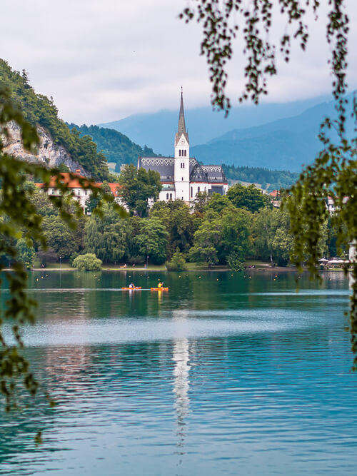A white church reflecting on the water of Lake Bled, Slovenia