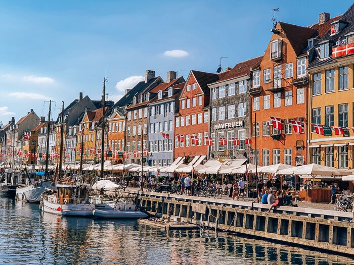Colorful Nyhavn canal lined with restaurants, old sailboats and historical houses in Copenhagen, Denmark.