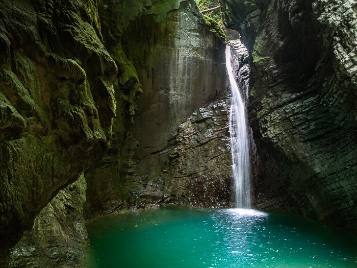 Mystical Kozjak Waterfall and its emerald basin surrounded by a dark limestone gorge