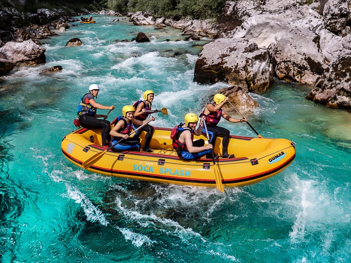 Me with a group of people sitting in a boat rafting on the Soca River, one of the best things to do in Slovenia.