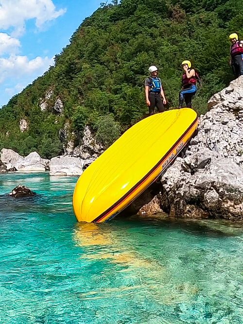 People sliding down a raft on a rafting tour in Slovenia