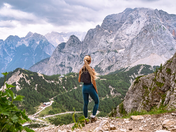 A woman hiking in Julian Alps in Slovenia and admiring the view of Vrsic Pass.