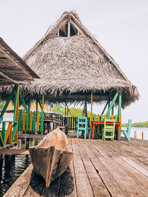 Caribbean-style restaurant with a straw roof built on stilts at Cayo Coral