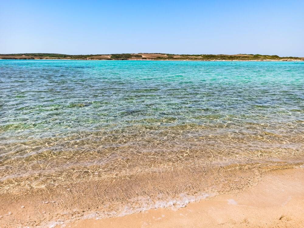 Shimmering turquoise water and golden sand at Antiparos Camping Beach, one of the best beaches in Antiparos.
