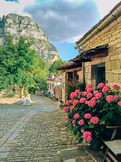 A cobblestone street lined with rustic houses in Papingo, one of the traditional stone-built Zagori villages in Greece