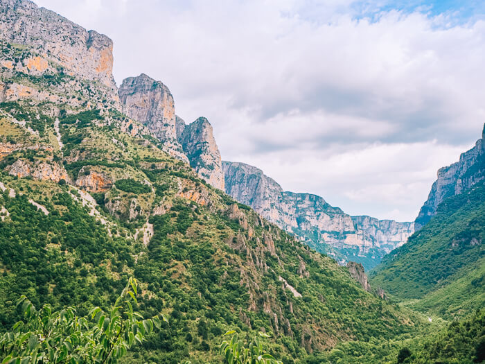 Views of towering cliffs and green valleys on the Vikos Gorge hike in Pindos National Park.