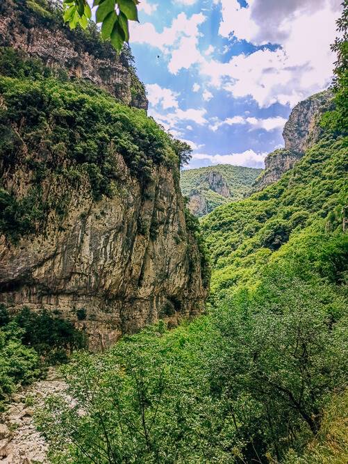 rugged rocky scenery and green vegetation on Vikos Gorge hike, a hidden gem in Greece