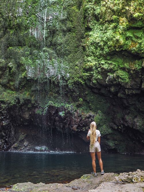 A woman admiring the Caldeirão Verde waterfall on Madeira Island