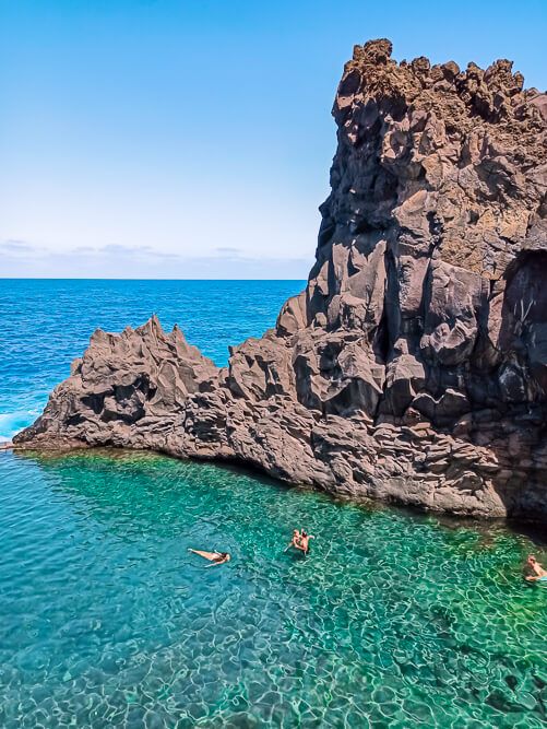 Cystal clear water and tall volcanic formations at Seixal lava rock pools.