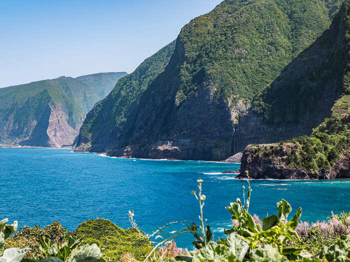 Green mountains rising out of the turquoise ocean at Seixal, one of the most beautiful places in this 7-day Madeira itinerary