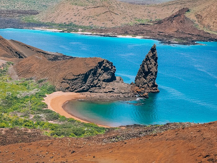 A secluded cove with golden sand and the iconic Pinnacle Rock at Bartolome Island