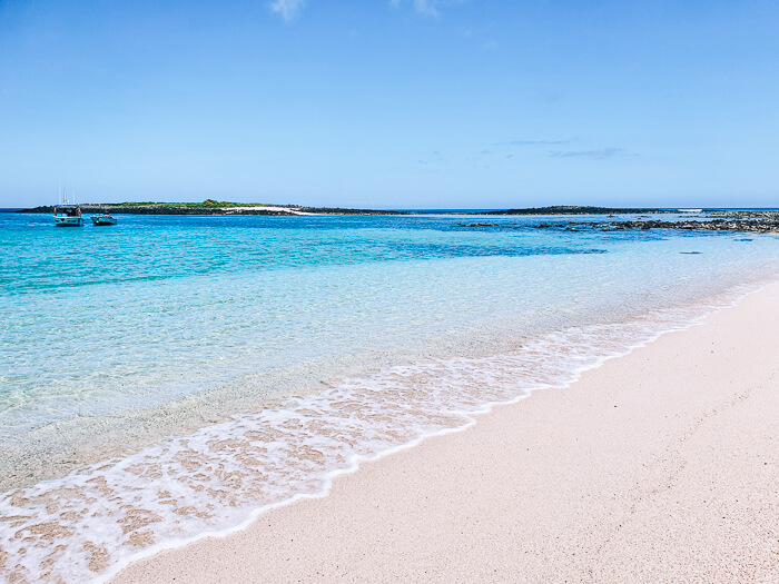 Coral sand and crystal clear water of the secluded Manglecito beach, one of the best Galapagos beaches