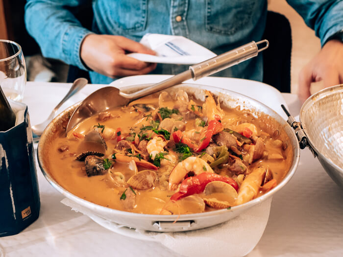 A large pot of seafood cataplana, a tasty Portuguese dish you should try during your Algarve road trip