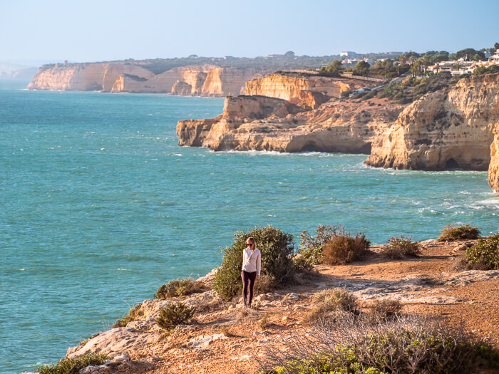 a woman hiking along the Seven Hanging Valleys Trail on the coast of Algarve, Portugal